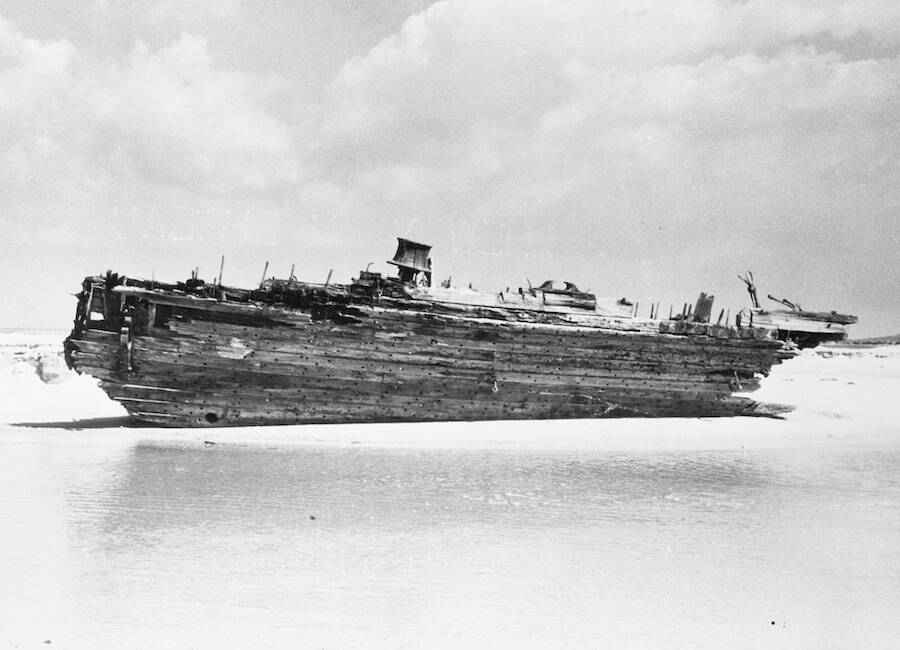 (Original Caption) Ghost Ship. Ocracoke Island, North Carolina: This is all that is left of the schooner Carroll A. Deering. It was washed up on the Ocracoke Island beach after breaking up on Diamond Shoals. Here a hurricane has blown the sands away exposing the battered hull, now she is almost sanded up again.